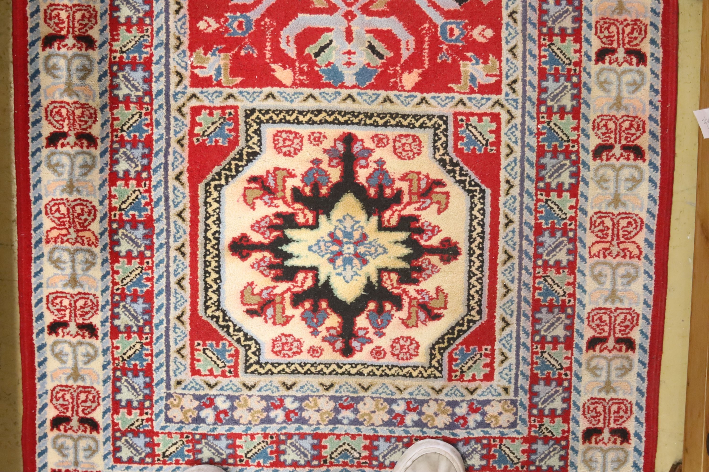 A Kazak style ivory ground rug, 144 x 64cm